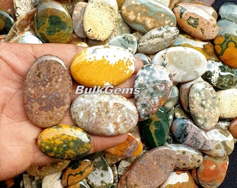 May include: A collection of polished, oval-shaped, ocean jasper stones. The stones are a mix of brown, yellow, green, and white with a variety of patterns. The stones are approximately 1-2 inches in length.