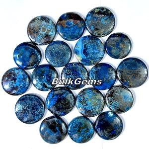 Op de afbeelding: Een verzameling ronde, gepolijste edelstenen in tinten blauw, bruin en groen. De stenen hebben een gevlekt uiterlijk, met wervelende patronen en kleurvariaties. De tekst "Bulk Gems" is zichtbaar op de afbeelding.