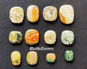 May include: Twelve polished ocean jasper cabochons in various shades of green, brown, white, and orange. The cabochons are all oval shaped and have a smooth, polished finish.