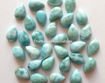 May include: A collection of 25 teardrop-shaped, light blue and white gemstone cabochons. The cabochons are smooth and polished, with a variety of patterns and swirls.