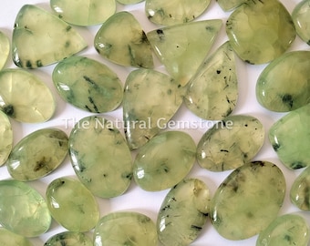 May include: A collection of green aventurine cabochons with black inclusions. The stones are various shapes and sizes, and have a smooth, polished finish.
