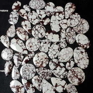 May include: A collection of 25 natural, white and brown,  polished,  cabochon gemstones. The stones have a unique, marbled pattern.