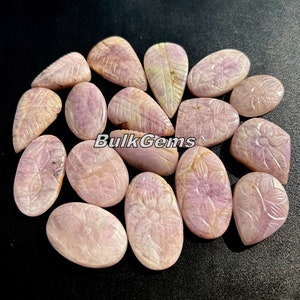 May include: A collection of 14 pink carved gemstone cabochons with leaf and flower designs. BulkGems is printed on the image.