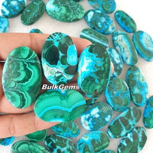 Puede incluir: Una colección de cabujones ovalados de turquesa y piedra verde. Las piedras tienen un patrón de remolino de azul, verde y blanco.