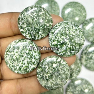 Könnte beinhalten: Eine Sammlung runder, polierter, natürlicher Stein-Cabochons in Grün und Weiß. Die Steine haben ein geflecktes, gesprenkeltes Muster.
