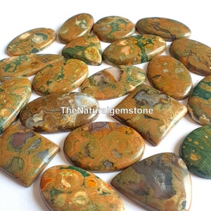 May include: A collection of 15 polished, oval-shaped, and rectangular ocean jasper cabochons. The stones are a mix of brown, green, and white with a variety of patterns and textures. TheNaturalgemstone is printed on one of the stones.