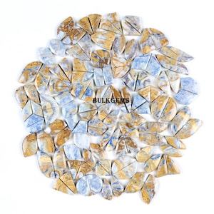 May include: A collection of polished gemstones in various shapes, including teardrops, triangles, and irregular forms. The stones feature a mix of blue, tan, and white colors, with visible veining and patterns. The text "BULKGEMS" is visible.