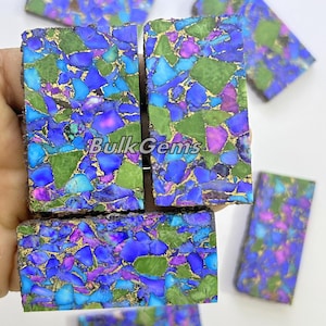 May include: Assortment of blue, green and purple gemstone cabochons with gold flecks. The cabochons are rectangular and have a polished finish.