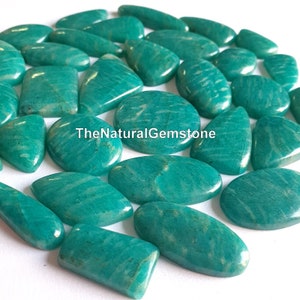 以下が含まれることがあります： 白い筋模様がそれぞれ異なる、緑色のアマゾナイトのカボションが20個集まったものです。カボションは、楕円形、涙型、長方形など、さまざまな形とサイズがあります。