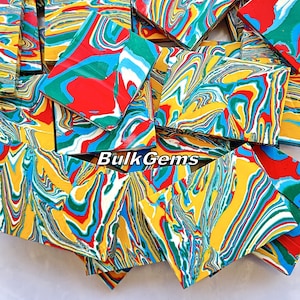 May include: A pile of colourful, marbled acrylic sheets. The sheets are a mix of red, yellow, green, blue, and white. The sheets are all different sizes and shapes. The text "BulkGems" is visible in the image.