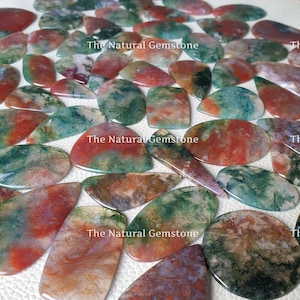 May include: A collection of green, red and white agate cabochons. The cabochons are smooth and polished, with a variety of patterns and textures. The Natural Gemstone is printed on the image.
