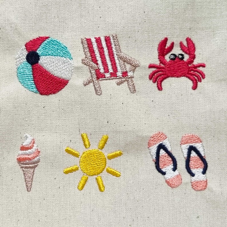 May include: Embroidered summer themed design featuring a beach ball, beach chair, crab, ice cream cone, sun, and flip flops.