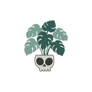 Puede incluir: Una planta de monstera verde en una maceta blanca con forma de calavera.