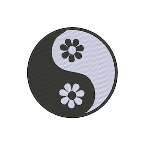 Puede incluir: Símbolo yin yang en blanco y negro con dos margaritas blancas, una a cada lado del símbolo.