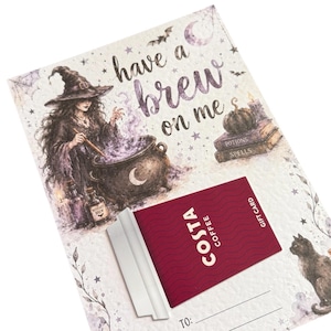 May include: A rectangular gift card holder featuring a witch stirring a cauldron with the text have a brew on me. A maroon Costa Coffee gift card is attached to the centre. The design includes illustrations of a black cat, pumpkins, and books.