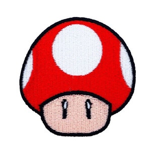 May include: Red and white mushroom-shaped patch with a black outline. The mushroom has a white spot on top and a brown face with two black eyes.