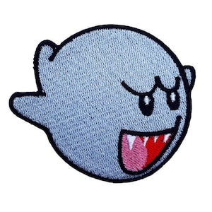 May include: An embroidered patch depicting a cartoon ghost with a toothy grin and black eyes. The ghost is grey with a pink tongue and is outlined in black.