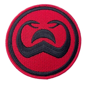 Könnte beinhalten: Roter und schwarzer gestickter Aufnäher mit einem stilisierten Schlangenkopfdesign. Der Aufnäher ist rund und hat einen schwarzen Rand.