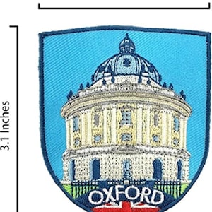 May include: Embroidered patch depicting the Radcliffe Camera in Oxford. The shield-shaped patch measures 6.35 cm wide and 7.87 cm high. The design includes the building, the word "OXFORD", and a Union Jack flag.