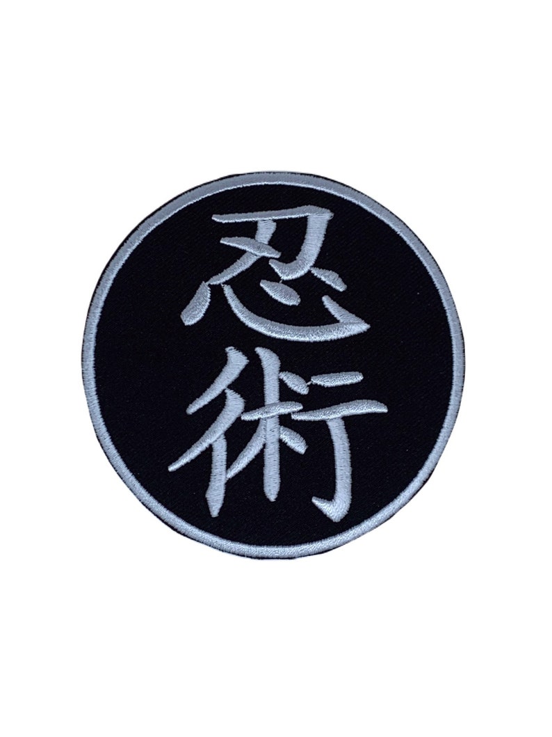 May include: A black and white embroidered patch with the Japanese characters for "忍術" (Ninjutsu) in a circle.