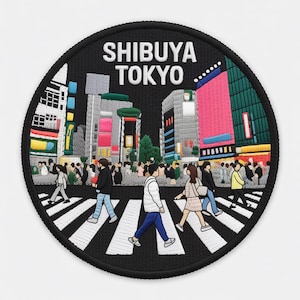 Pode incluir: Patch bordado circular com o cruzamento de Shibuya em Tóquio, Japão. O patch tem uma borda preta e o texto "SHIBUYA TOKYO" em branco. O design mostra pessoas atravessando a rua, com edifícios ao fundo.