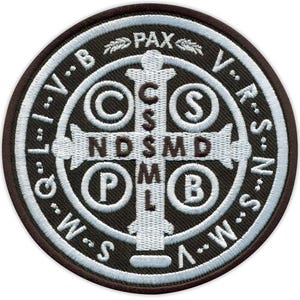 Peut inclure: Un écusson brodé marron et blanc avec une croix et les mots "Pax" et "V.R.S.N.S." autour du bord.