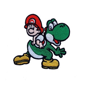 May include: An embroidered patch featuring a green Yoshi carrying a baby Mario on its back. Yoshi is wearing a white diaper and has a red cap. The patch is perfect for adding a touch of fun to clothing, bags, or other accessories.