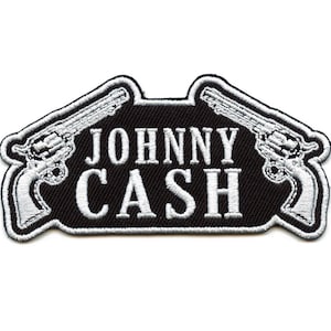 May include: Black and white embroidered patch with two pistols flanking the text "JOHNNY CASH".