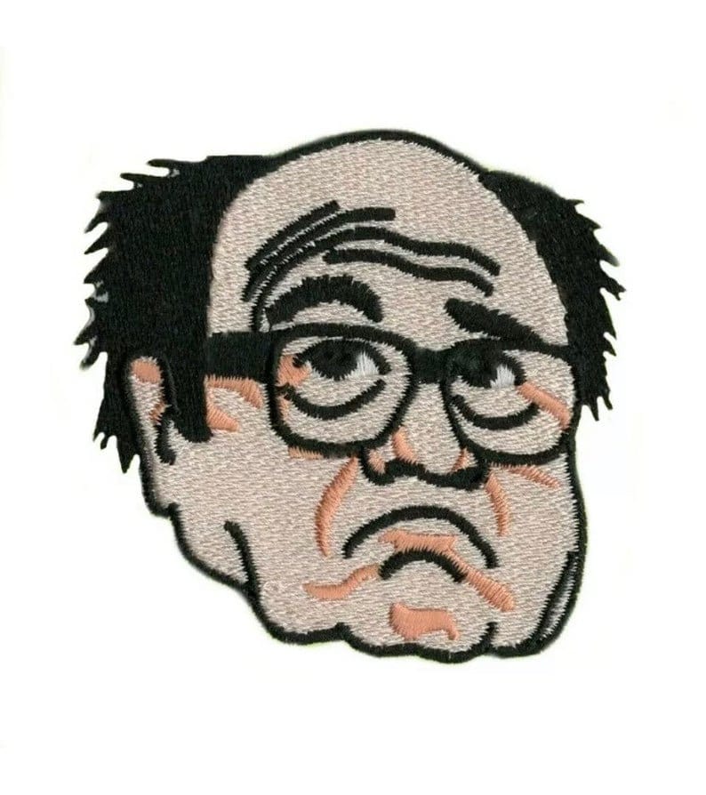 Puede incluir: Parche bordado de un hombre de dibujos animados con pelo negro, gafas y una expresi&oacute;n de enfado.