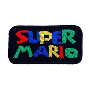 May include: Embroidered patch featuring the iconic "Super Mario" logo in a colorful design. The letters are outlined in black and filled with red, blue, yellow, and green.