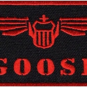 May include: Red and black embroidered patch with a winged shield and the word "GOOSE" in red lettering.
