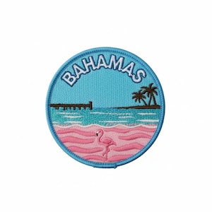 Puede incluir: Parche bordado con una escena de playa tropical. El parche tiene un borde azul con la palabra "BAHAMAS" en blanco. La escena incluye un flamenco rosa, arena rosa, agua azul, un muelle y palmeras.