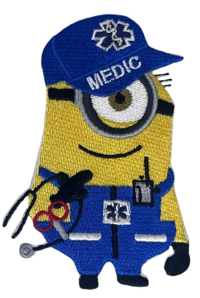 May include: Embroidered patch featuring a yellow Minion character in a blue medic uniform and cap. The cap reads "MEDIC" and has a white star of life emblem. The Minion holds a stethoscope and scissors, with a walkie-talkie on its uniform.