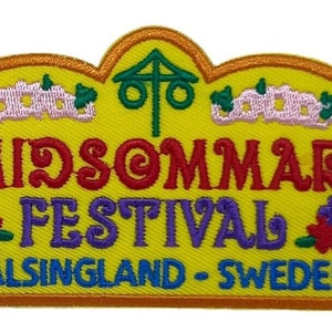 May include: A yellow embroidered patch with the text "Midsommar Festival Hälsingland - Sweden". The patch features a stylised tree with a cross on top, flowers, and a crown.
