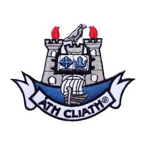 May include: Embroidered patch featuring a gray castle with red flames, a white bird on top, and a blue ship in front. The castle has a crest with a blue and white design. A white banner with the text "ÁTH CLIATH®" wraps around the bottom.