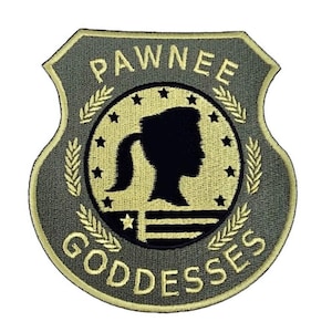 Może przedstawiać: Naszywkę haftowana w kolorze zielonym i brązowym z napisem "Pawnee Goddesses" i sylwetką głowy kobiety z kucykiem w środku koła.