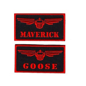 May include: Two black and red embroidered patches with red wings and a red emblem. The top patch says "MAVERICK" and the bottom patch says "GOOSE".