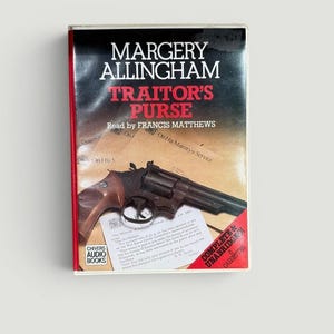 May include: A vintage audio cassette of Margery Allingham's "Traitor's Purse," read by Francis Matthews. The cover features a revolver and text on a red and black background. Includes "Chivers Audio Books" branding and "Complete & Unabridged" text.