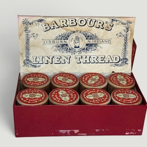 May include: An open red box of Barbour's Linen Thread. The box lid displays the brand name, location, and product type. Inside are eight spools of thread with red and cream labels, each marked "CORD 60 OUNCE".