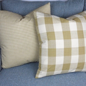 May include: Two decorative throw pillows with a gingham pattern. One pillow is a smaller gingham pattern in beige and white. The other pillow is a larger gingham pattern in beige and white.
