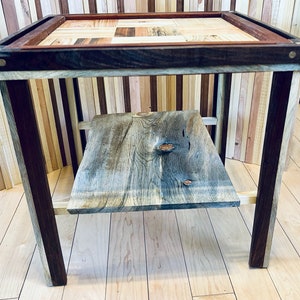 May include: A wooden end table with a checkerboard-patterned top and a lower shelf. The table is made from reclaimed wood and has a rustic, farmhouse style.