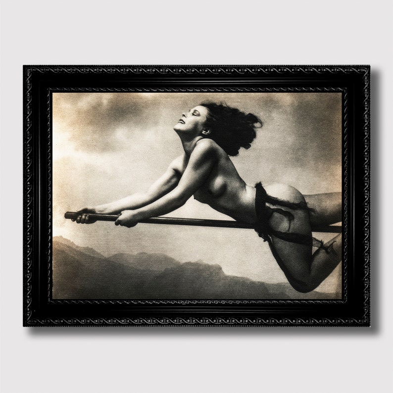 A black-and-white vintage-style photo of a nude woman soaring joyfully on a broomstick through a cloudy sky. Her windswept hair and expression of ecstasy evoke a powerful blend of freedom, mysticism, and feminine energy, with distant mountains completing the atmospheric backdrop.