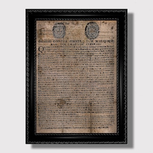 Pode incluir: Documento antigo emoldurado em preto, com texto em latim e dois selos circulares. O papel tem um tom sépia, indicando idade. A moldura preta tem uma borda decorativa. Um artefato histórico.