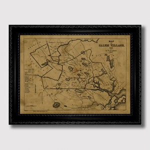 Op de afbeelding: Ingelijste vintage kaart van Salem Village, 1692, in een zwart, sierlijk frame. De kaart is gedrukt op verouderd papier met zwarte inkt, met de indeling van het dorp met gelabelde gebieden en tekst. Het frame voegt een klassieke touch toe aan het historische kunstwerk.