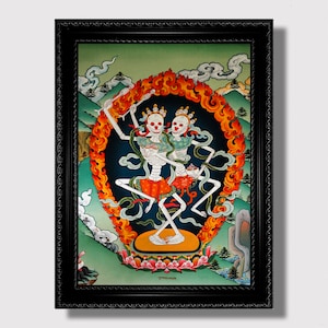 May include: A framed painting depicting two skeletal figures dancing in a fiery mandala. The figures are adorned with colourful clothing and jewellery, and the mandala is surrounded by flames and clouds. The painting is set against a green background and features the text "སྒྲོལ་མ་" in the lower centre.