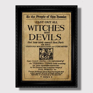 May include: A framed print with a black ornate frame. The print has a parchment-like background with black text that reads "CAST OUT ALL WITCHES and DEVILS." It includes an illustration and the year 1693.