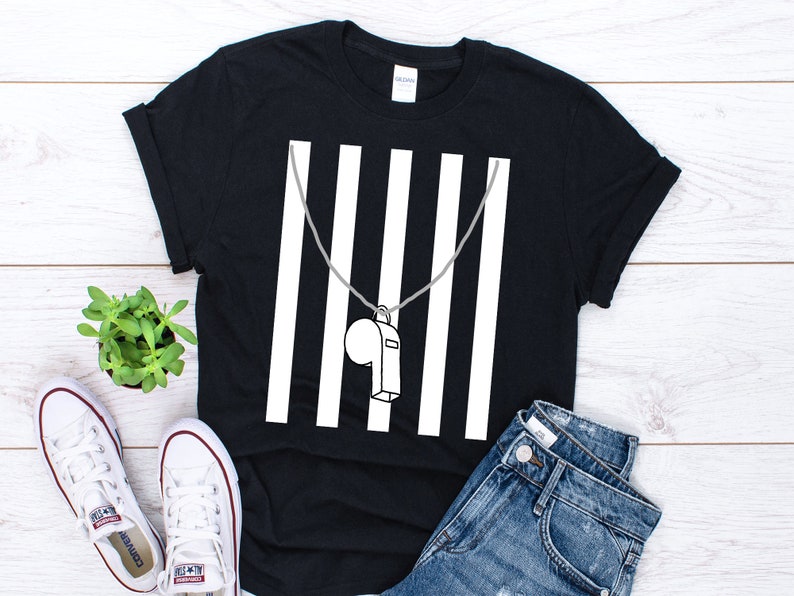 May include: Black t-shirt with a white graphic of a whistle hanging from a chain in front of white vertical stripes.
