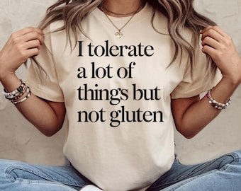 May include: A white t-shirt with black text that reads "I tolerate a lot of things but not gluten".
