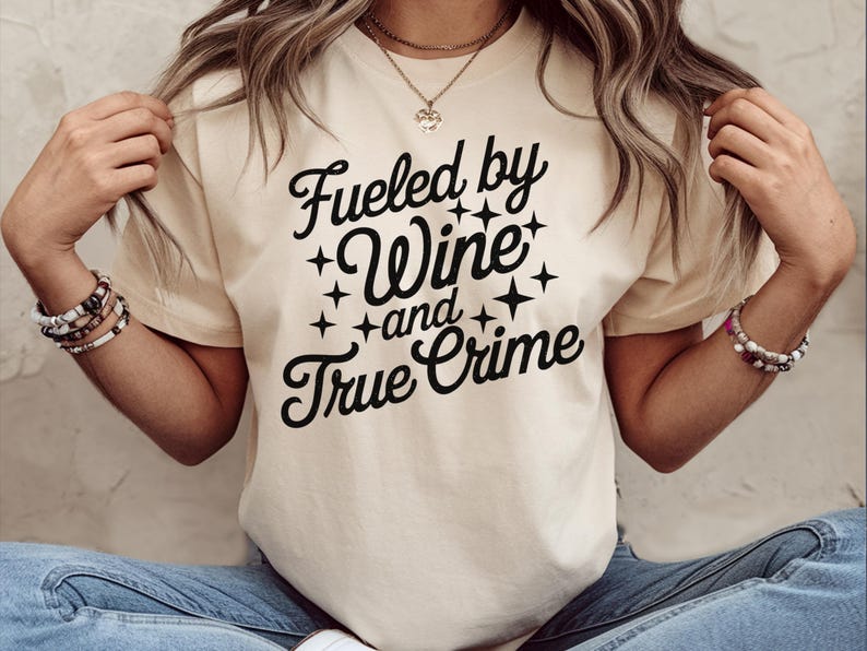 May include: A white t-shirt with black text that reads "Fueled by Wine and True Crime".