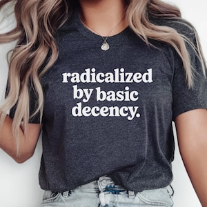 May include: A dark gray t-shirt with white text that reads "radicalized by basic decency."